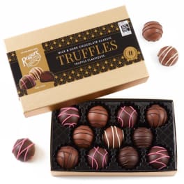 Box of assorted chocolate truffles with a few pieces outside the tray