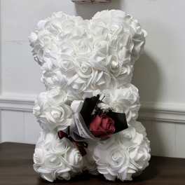 White teddy bear with a small rose bouquet and a "happy mother day" sign