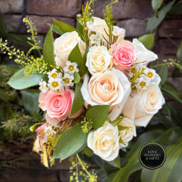 Bouquet of cream and pink roses with small white filler flowers