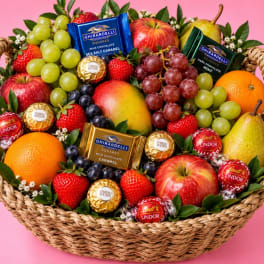 Fruit basket with apples, grapes, strawberries, oranges, pears, and chocolates
