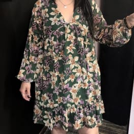 Woman wearing a dark green floral dress with long sleeves