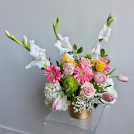 Pink and white mixed flower arrangement in a gold vase