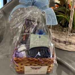 Gift basket with hair clip, lotion, and other small items wrapped in clear plastic