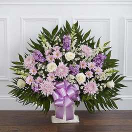 Lavender and white floral standing spray with a purple ribbon
