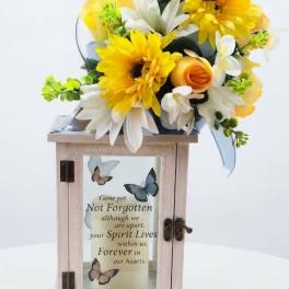 Yellow and white floral arrangement on a memorial lantern