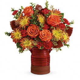 Orange roses and red-yellow mums in a red vase