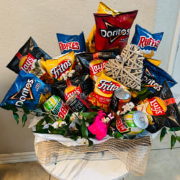 Snack bouquet with chips, soda cans, and faux flowers in a burlap-wrapped basket