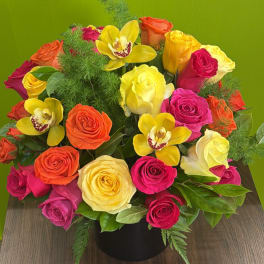 Colorful rose bouquet with yellow orchids in a black vase