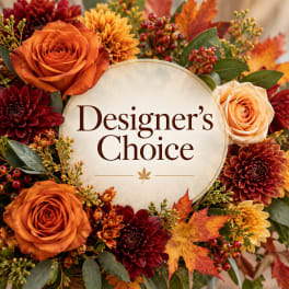 Autumn floral arrangement with orange roses and burgundy mums around a Designer's Choice sign