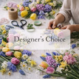 Hands arranging colorful tulips and mixed flowers on a table