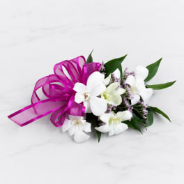 White orchid bouquet with a magenta ribbon bow
