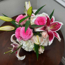 Pink roses and white lilies arranged in a low bouquet