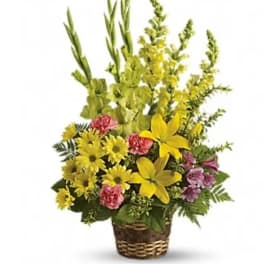 Yellow and pink floral arrangement in a woven basket