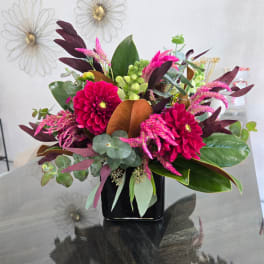 Pink and magenta flowers arranged in a black vase