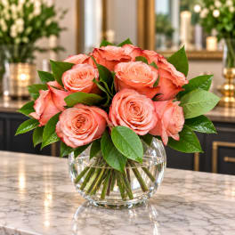 Pink roses arranged in a clear glass bowl vase