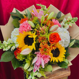 Mixed bouquet with sunflowers, roses, lilies, and pink carnations