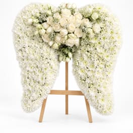 White floral funeral spray on a wooden easel