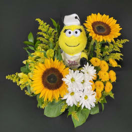 Sunflower and daisy arrangement with a plush bee in the center