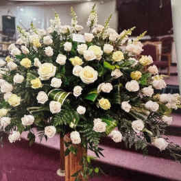 Large arrangement of white and pale yellow roses in a tall vase