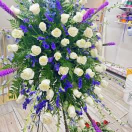 Large standing floral spray with white roses and purple-blue accents