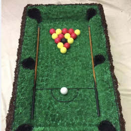 Miniature pool table made of green material with colored balls and cues
