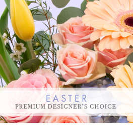 Pastel Easter arrangement with pink roses, a yellow tulip, and a peach gerbera daisy in close-up view
