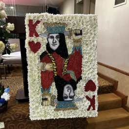 Large floral tribute board with a playing-card design in white flowers