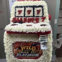 Floral display shaped like a slot machine with cash attached