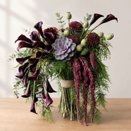 Bouquet with dark calla lilies, burgundy blooms, and a succulent centerpiece
