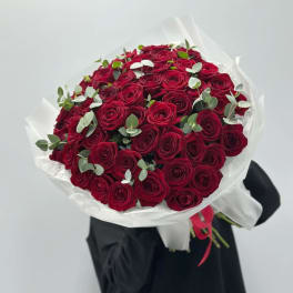 Large bouquet of red roses wrapped in white paper