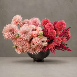 Pink and magenta dahlia arrangement in a black bowl vase