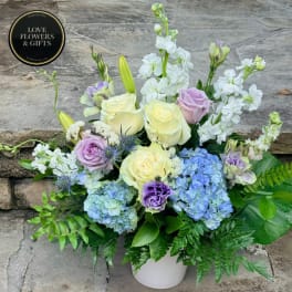 Pastel roses, hydrangeas, and white stock in a white vase
