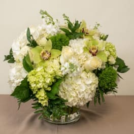 White and green floral arrangement in a clear glass vase