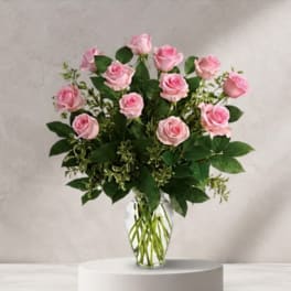 Pink roses arranged in a clear glass vase