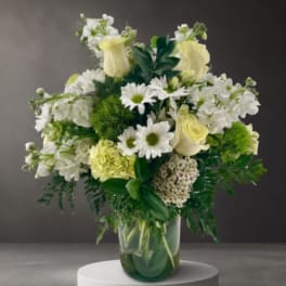 White and pale yellow flowers arranged in a glass vase