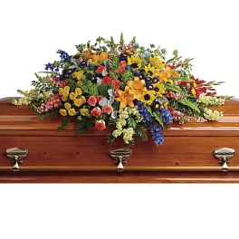 Colorful floral casket spray on a wooden coffin