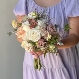 Handheld bouquet of white and blush roses with mixed blooms