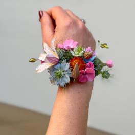 Colorful floral wrist corsage on a person's wrist