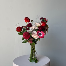 Bouquet of red, pink, and white flowers on a round pedestal