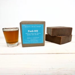 Soap bars and a whiskey shot glass on a white surface