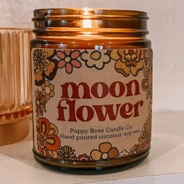 Amber glass candle jar labeled "moon flower" with floral graphics