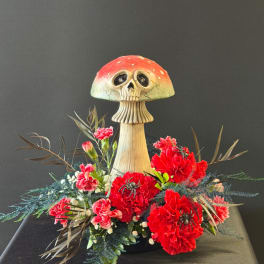 Floral arrangement with red carnations and a skull mushroom decoration