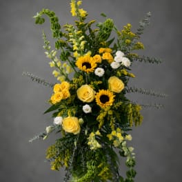 Tall yellow and white floral standing spray on an easel