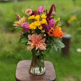 Mixed bouquet of bright flowers in a clear glass vase