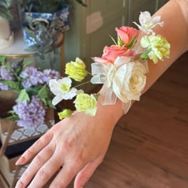 Floral wrist corsage with pink and white blooms on a sheer ribbon band
