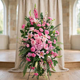 Tall pink floral standing arrangement with roses, lilies, and carnations