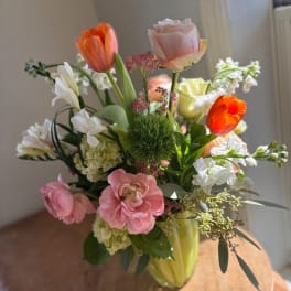 Mixed bouquet of tulips, roses, and white blooms in a vase