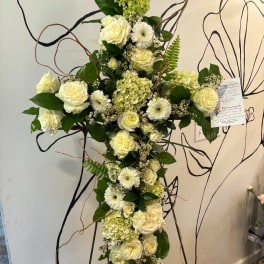 Tall white floral cross with roses and daisies