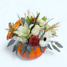 White floral arrangement in an orange pumpkin-shaped container