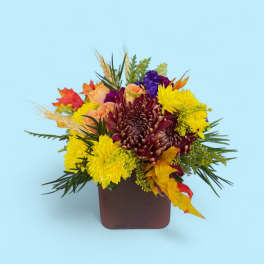 Autumn bouquet of yellow and burgundy flowers in a square vase